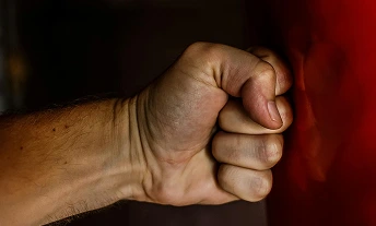 A hand holds a vibrant red object, showcasing its color and texture against a neutral background